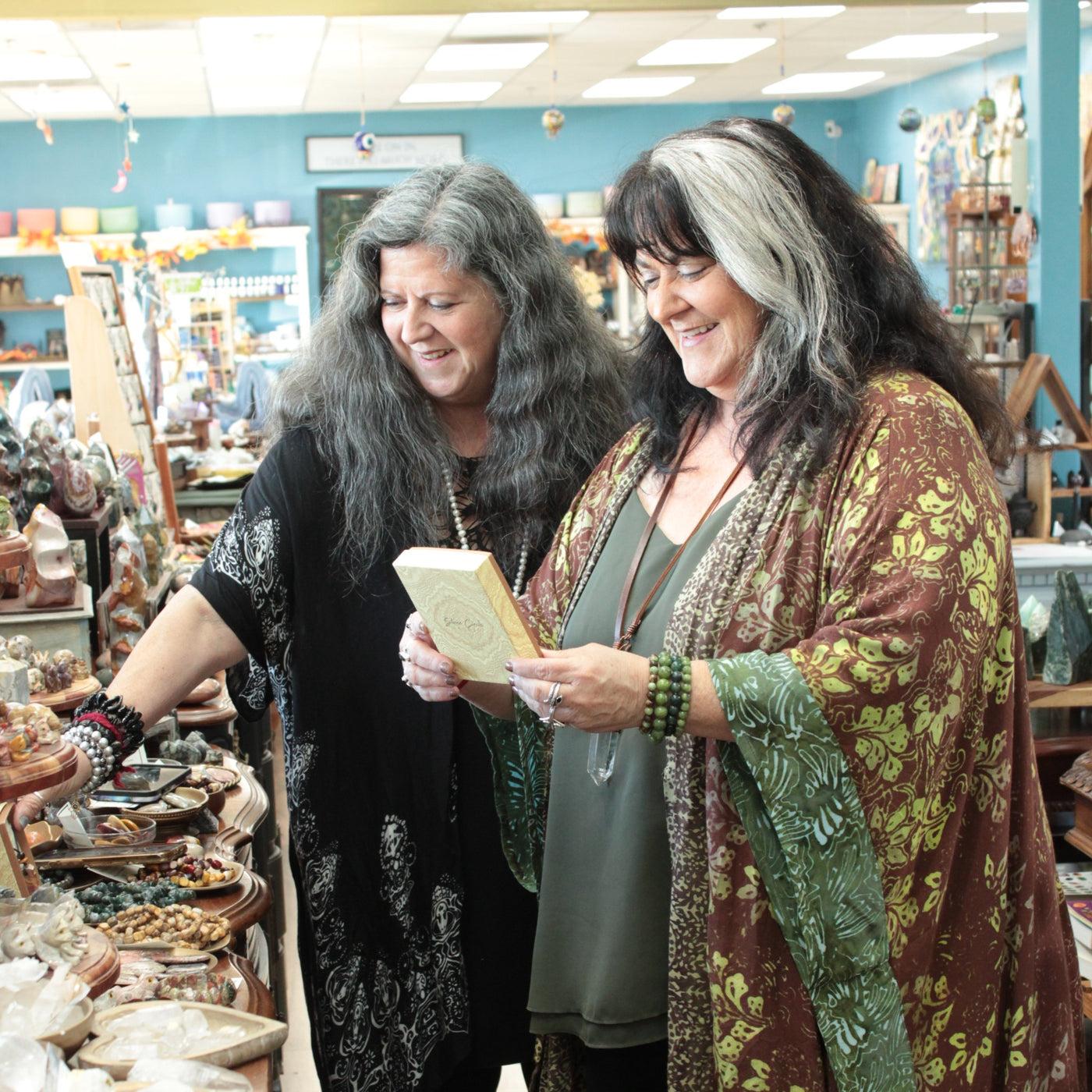 Suzanne and Toni in their shop looking at products